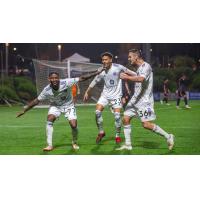 Louisville City FC forward Enoch Mushagalusa and midfielders Elijah Wynder and Paolo DelPiccolo (L to R) celebrate